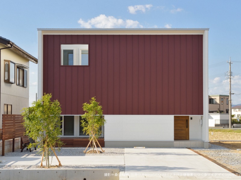 上下階に収納コアを設けた、赤い垂れ壁の家